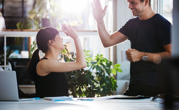 colleagues high fiving in office