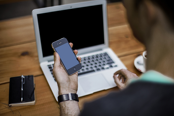 man using laptop and iphone