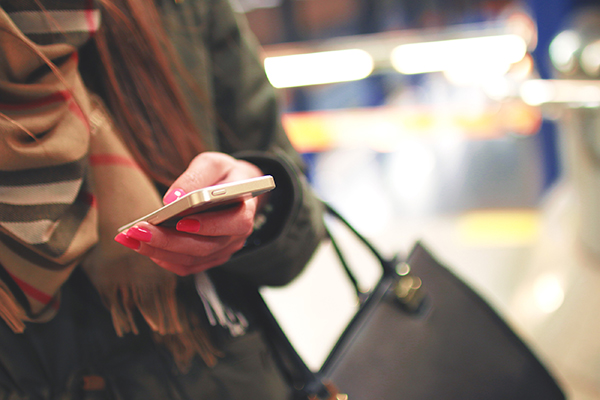 woman with a phone in her hand, perhaps using facebook messenger for business