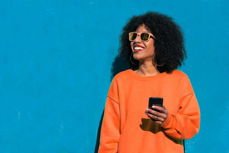 smiling woman using smartphone to engage with customer service automation